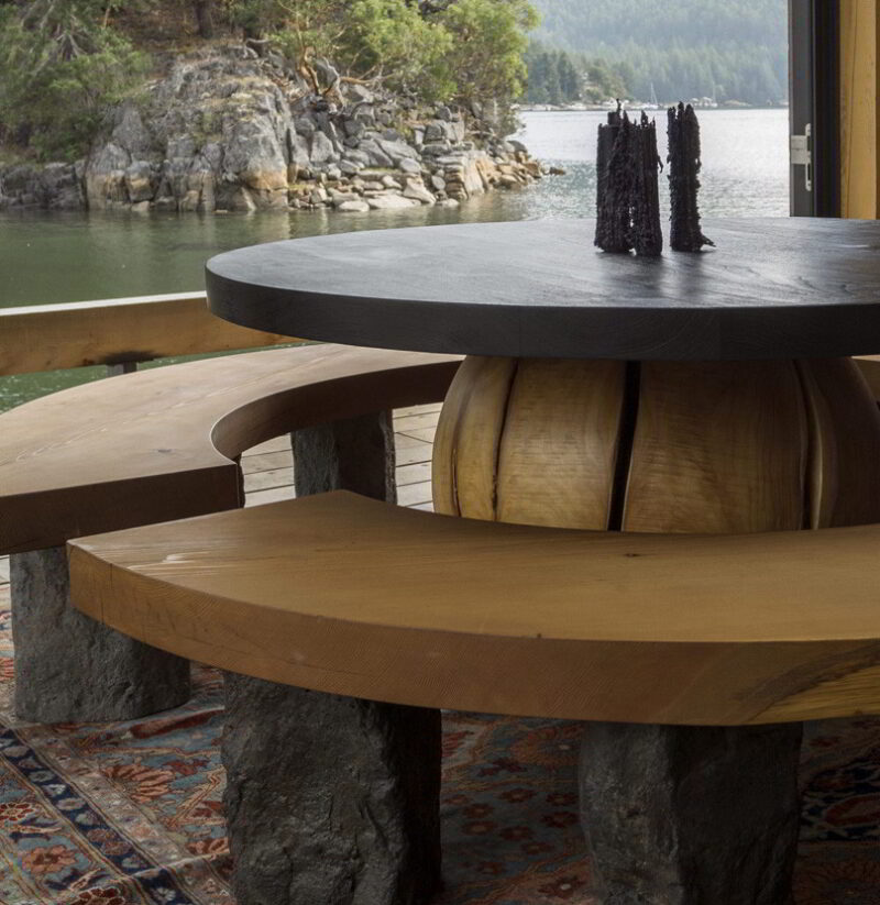 Island dining table and benches with an ocean view.