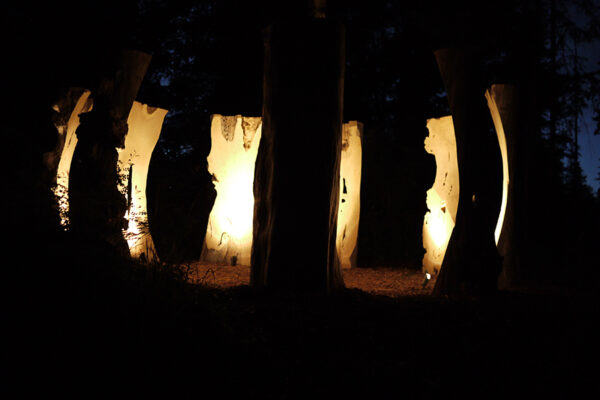 Nine Sentinel sculptures are pictured installed in a circular formation at the Van Dusen Botanical Gardens.