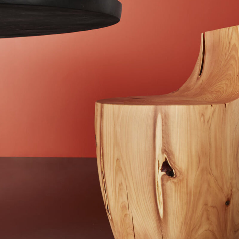 The grain of the Chelsea stool is pictured against a red background.